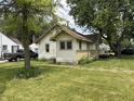 Cozy home showcasing light yellow siding and a lush green lawn at 1201 N Canal St, Alexandria, IN 46001