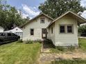 Charming home with light yellow siding, front yard, and a detached garage at 1201 N Canal St, Alexandria, IN 46001