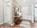 Welcoming foyer boasts elegant wainscoting, hardwood floors, and a stylish console table at 12594 Pasco St, Fishers, IN 46038