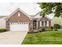 Charming brick home featuring a well-maintained lawn, two-car garage, and manicured landscaping at 13091 Duval Dr, Fishers, IN 46037