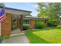 Charming brick home entrance with covered porch, decorative columns, and landscaped garden at 1506 Bowman Dr, Greenfield, IN 46140