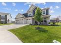 Beautiful two-story home with a three-car garage, a quaint front porch, and mature landscaping at 221 Underland Cir, Westfield, IN 46074