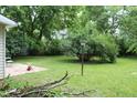 Large backyard with mature trees and a concrete patio at 2232 Fairview St, Anderson, IN 46016