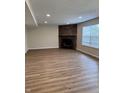 Bright living room features a stone fireplace, recessed lighting, and wood-look floors at 2540 Lullwater Ln, Indianapolis, IN 46229