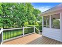 Inviting wooden deck with white railings and a screened-in porch overlooking a lush, green backyard at 2614 Daylily Ct, Westfield, IN 46074