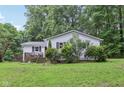 Exterior view showcases the charming white home with a cozy deck and well-maintained landscaping at 2640 S Silcox Rd, Paragon, IN 46166
