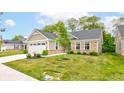 This well-maintained home is surrounded by a lush green lawn and mature trees at 2747 Stonebridge Dr, Lebanon, IN 46052