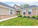 Inviting front yard with lush green grass and stone accents on the home's exterior at 2747 Stonebridge Dr, Lebanon, IN 46052