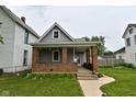 Inviting two-story home featuring a classic brick porch and well-maintained front yard at 305 N Warman Ave, Indianapolis, IN 46222