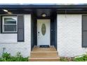 Close-up of the front door with a decorative glass insert, complemented by a tiled porch and black shutters at 3141 Citadel Ct, Indianapolis, IN 46268