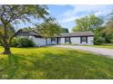 Charming single-story home featuring a white brick exterior, black shutters, an attached garage, and a well-maintained front yard at 3141 Citadel Ct, Indianapolis, IN 46268