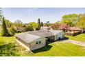 An aerial view of a single-story brick home in a residential neighborhood with mature trees at 3215 E 10Th St, Anderson, IN 46012