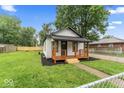 Lovely home with a manicured lawn, complemented by a beautiful wooden porch at 3453 W 12Th St, Indianapolis, IN 46222