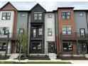 Exterior angle of new townhouses with gray siding, black brick, and individual balconies at 449 Shade St, Carmel, IN 46290