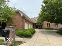 Brick home exterior with a three-car garage, mature landscaping, and a well-maintained driveway at 458 Burlington Ln, Carmel, IN 46032