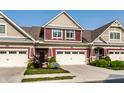 Townhome showcasing a two-car garage, attractive landscaping, and a classic architectural design at 478 Firefly Ln, Carmel, IN 46032