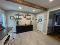 Open kitchen area with dark cabinets, wooden beam, floating shelves and view of the backyard at 537 N 17Th St, Noblesville, IN 46060