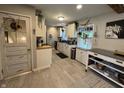Bright kitchen features white cabinets, stainless appliances, hanging plants, and access to the rest of the home at 537 N 17Th St, Noblesville, IN 46060