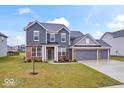 Charming two-story home with brick and siding, a manicured lawn, and a three-car garage at 5655 Lighthouse Dr, Brownsburg, IN 46112