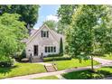 Beautiful white brick home with a well-manicured lawn and lush landscaping at 5681 Carrollton Ave, Indianapolis, IN 46220