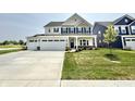 Attractive two-story home with a spacious three-car garage, lovely landscaping, and a welcoming entrance at 581 Roosevelt St, Fortville, IN 46040