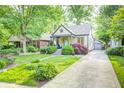 Charming home showcasing lush greenery, flowering plants, and a welcoming front yard at 6045 Haverford Ave, Indianapolis, IN 46220