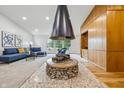 Spacious living room with a striking cone fireplace, built-in shelving, and comfortable seating with large windows at 6704 Hoover Rd, Indianapolis, IN 46260