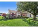 Attractive home featuring a lush green lawn, mature trees, and an attached garage at 7456 Jack Pine Ct, Avon, IN 46123