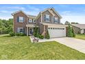 Two-story home featuring brick and vinyl siding, a well-kept lawn, and mature landscaping at 7603 Merrick Dr, Brownsburg, IN 46112