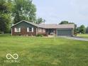 Charming brick ranch home with well-manicured front lawn, mature trees, and an attached two-car garage at 7870 E County Road 150 S, Avon, IN 46123