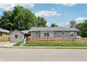 Charming single-story home with a well-maintained yard and natural wood fence under a bright blue sky at 802 N Tuxedo St, Indianapolis, IN 46201