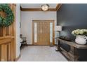 Bright foyer features a wood door with decorative glass, ceramic tile floor, and a stylish table with decor at 815 Copperfield Ln, Danville, IN 46122