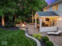 Backyard featuring a covered patio with string lights and a fire pit area at 9703 Fortune Dr, Fishers, IN 46037