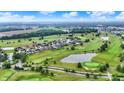 Stunning aerial view of a residential area adjacent to a lush golf course with multiple water features at 1135 Maclaren Ct, Franklin, IN 46131