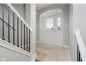 Inviting entryway with white walls, tile flooring, a staircase, and a door with sidelights at 11872 Salerno Ct, Carmel, IN 46032