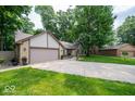 Ranch-style home with a spacious driveway, attached garage, and lush green lawn at 1304 Old Hickory Cir, Greenwood, IN 46142