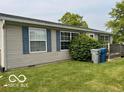 Home exterior with blue shutters and lush lawn; trash cans by the home at 135 Sunset Ct, Cicero, IN 46034