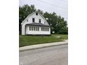 A white house with a front porch and green lawn shows the property's curb appeal at 1630 E 18Th St, Indianapolis, IN 46218
