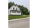 A white house with a front porch and green lawn shows the property's curb appeal at 1630 E 18Th St, Indianapolis, IN 46218
