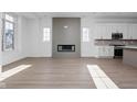 Bright living room featuring a modern fireplace and a seamless flow into the kitchen at 1655 Fernley Dr, Westfield, IN 46074