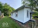 Angle shot of a one story home showing neutral siding, trimmed windows, front entrance, and green lawn at 1720 E Cornell Ave, Muncie, IN 47303