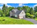 View of home featuring an attached two-car garage and well maintained lawn at 1898 Corniche Dr, Zionsville, IN 46077