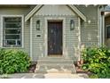 Close-up of the front door with sidelights and a small porch with three steps and a welcome mat at 2158 S Garfield Dr, Indianapolis, IN 46203