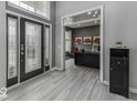 Inviting foyer with a glass-paneled door and sleek flooring, leading to a home office at 2502 Colinbrook Pkwy, Greenwood, IN 46143