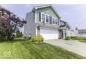 Corner view of a home featuring a two-car garage, well maintained lawn, and landscaped garden at 2786 Longleaf Dr, Greenwood, IN 46143
