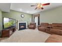 Comfortable living room with a cozy fireplace, plush seating, and ceiling fan at 3068 Reflection Ct, Greenwood, IN 46143