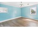 Bright, empty bedroom featuring light blue walls, white trim, and light hardwood floors at 4020 N Mitthoefer Rd, Indianapolis, IN 46235