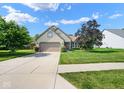 Beautiful home with a lush green lawn, mature trees, and a paved driveway leading to the garage at 4342 Sequoia Ct, Greenwood, IN 46143