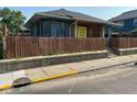 Charming single-story home with a fenced yard and bright yellow door, creating a welcoming curb appeal at 4402 E New York St, Indianapolis, IN 46201