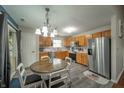 Eat-in kitchen featuring stainless steel appliances, oak cabinets, and luxury vinyl plank flooring at 441 E Pine Ridge Dr, Westfield, IN 46074